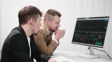 İki çok yönlü iş analisti bir dizüstü bilgisayar kullanarak veri yönetimini tartışıyor. Konsept danışmanlık, eğitim ve istemci desteği bir ofis toplantısı sırasında çevrimiçi teknolojiler yoluyla.