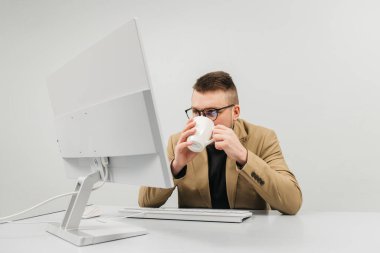 Bir iş adamı, finans müdürü ya da adam toplayıcı, modern bir ofiste bilgisayar başında çalışıyor. Konsept, rahat bir çalışma ortamında bir profesyonelin odaklanma ve üretkenliğini göstermektir..