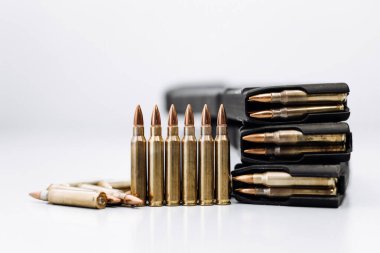 Beyaz arka planda bir tüfekle kurşunlara yakından bakın.