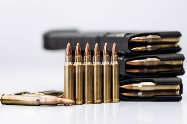 Beyaz arka planda bir tüfekle kurşunlara yakından bakın.