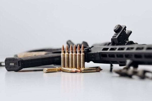 close up view of bullets with a rifle on a white background