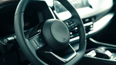 Modern bir direksiyona yakın çekim, parlak tasarımını ve gelişmiş özelliklerini vurgulayarak, otomotiv iç mekanlarında lüks ve yenilikçi bir atmosfer yaratır.