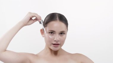 Kadın cam damlaları kullanarak serum uyguluyor.