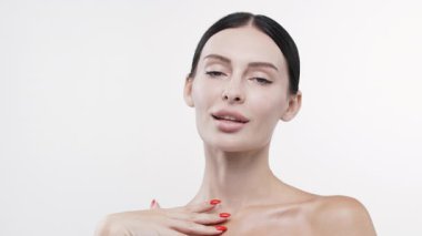 Boynuna dokunan kadın pürüzsüz bir cilt gösteriyor.