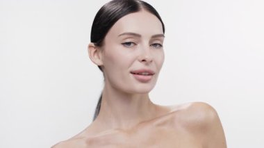 Gülümseyen kadın parlak beyaz arka planda poz veriyor