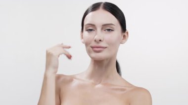 Gülümseyen kadın omzuna dokunuyor beyaz arka plan