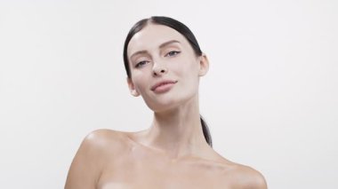 Beyaz arka planda poz veren gülümseyen genç kadın