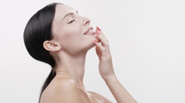 Gülümseyen kadın yumuşak tenine dokunuyor