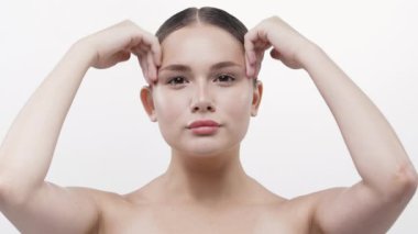 İki eliyle masaj yapan genç bir kadın.