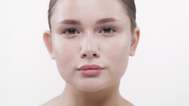 Kameraya bakan genç kadın tarafsız bir ifadeyle