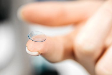 Parmak ucu yakın planda kontak lens dengelenmesi