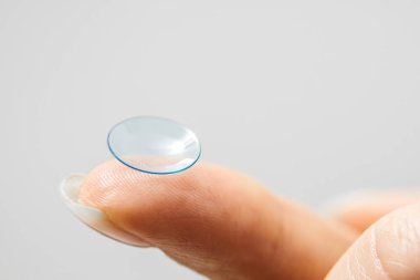 Kişi lensi parmak ucu yakın plan üzerinde dinleniyor