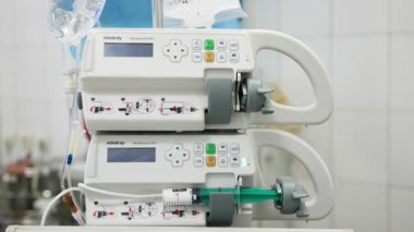 Hastane ortamında tıbbi infüzyon pompaları görünüyor.