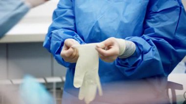 Mavi elbise giyen profesyonel tıp doktoru eldiven takıyor.