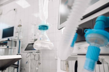 Modern bir ameliyathanede tıbbi ekipmanlar, solunum cihazları, monitörler ve steril çevre ile anestezi makinesinin altını çizerek cerrahi teknoloji ve prosedürlere hazırlık