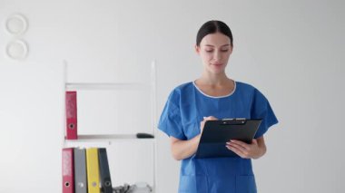 İçerideki panoya not yazan kadın hemşire.