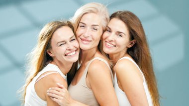 Farklı etnik kökenlere sahip üç kadın sağlıklı bir kaplıcada neşeli bir anı paylaşıyor. Parlayan ciltlerini ve doğal güzelliklerini vurguluyorlar. Rahatlama ve kendine bakımı teşvik eden rahatlatıcı bir ortam ile çevrili.