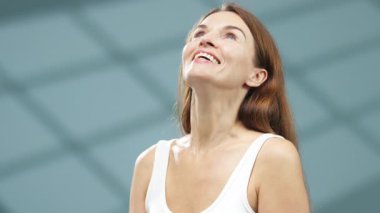 Bulanık arka plana bakan gülümseyen kadın.