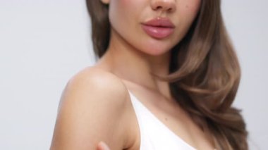 Çıplak omzuna dokunan genç bir kadının yakın çekimi.