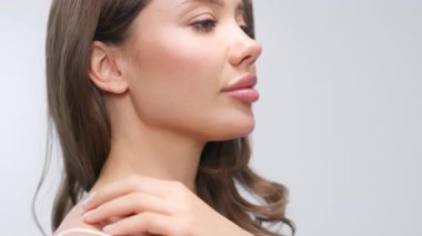 Genç bir kadın omuzlarına rahatça dokunuyor.