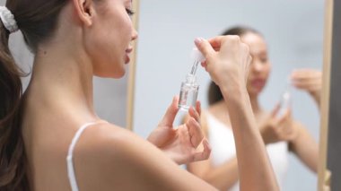 Kadın cam damlaları kullanarak serum uyguluyor.