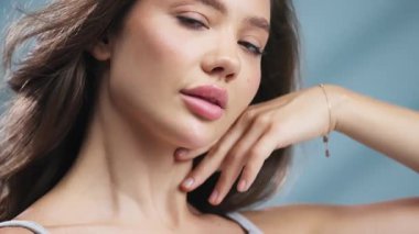 Rahat bir ifadeyle çeneye dokunan kendinden emin bir kadın.