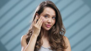 Genç kadın usulca gülümserken nazikçe yüzüne dokunuyor.