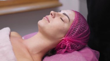 Rahatlamış kadın yüz tedavisi sırasında dinleniyor.