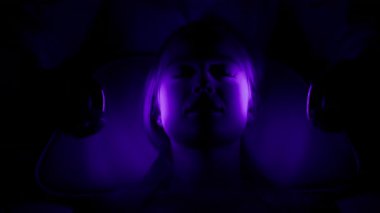 Parlak mor ışık terapisinde yatan bir kadın.