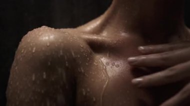 Omuzdan aşağı akan su damlacıklarını gösteren yakın çekim