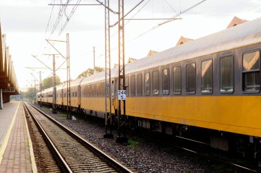 Sarı yolcu treni boş platformun yanında bekliyor.