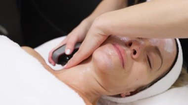 Kaplıcada kadın rahatlatıcı yüz masajı yaptırıyor.