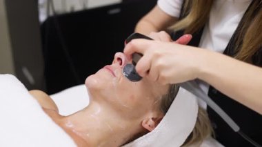 Kaplıcada rahatlatıcı yüz bakımı gören bir kadın