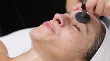 Kadın yüz bakımı seansı yapıyor.