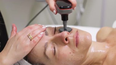 Cihaz kullanılarak yüz bakımı gören kadın