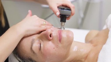 Kadın spa kliniğinde yüz bakımı yaptırıyor.