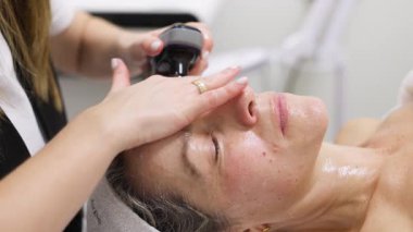 Kadın yüz bakımı seansı yapıyor.