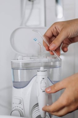 Diş fırçasını modern su temizleme cihazına yerleştiriyorum