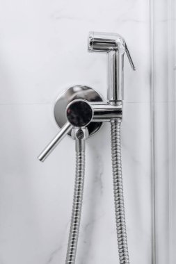 Duvarın yanında asılı modern krom bide spreyi