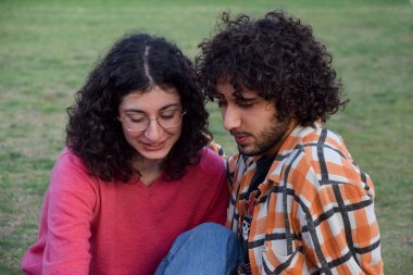 Romantic couple sitted at the park talking and hugging
