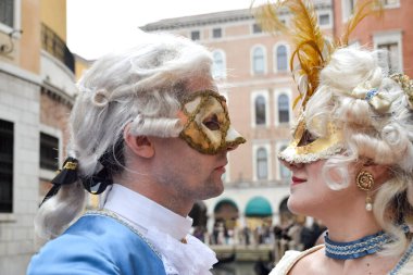 Couple watching themselves dressed up for Venice Carnival wearin