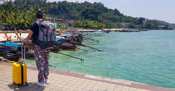 年轻的亚洲男子带着他的手提箱在菲菲岛港口度假时拍照 — 图库照片
