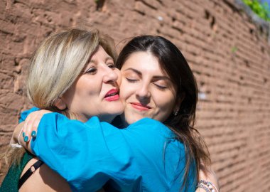 Anne ve kızı sarılıyor ve sevgisini dile getiriyorlar..