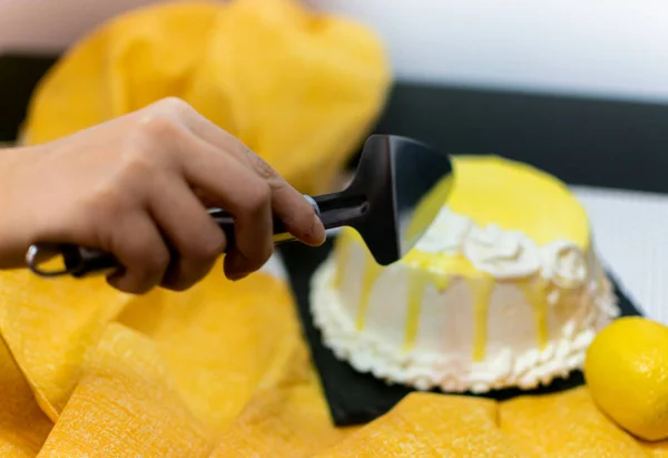 Hand cutting lemon cake. The concept of homemade pastry, cooking cakes.