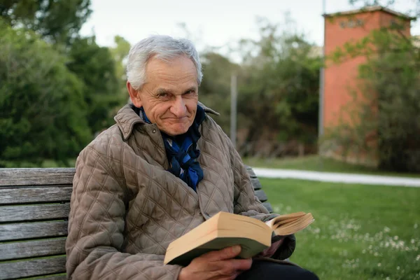 Старик Седыми Волосами Читает Книгу Сидящую Скамейке Парке — стоковое фото