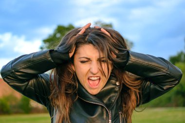 Genç bir kadın çok kızgın, bağırıyor ve stresli. Parkta saçı olan biri. Sorunlar ve stres konsepti.