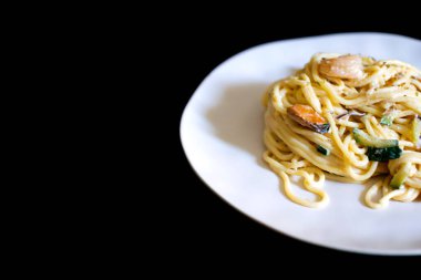 Karidesli, kabuklu ve kabaklı deniz ürünleri spagettisi. Siyah arkaplan ile kapat