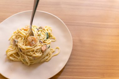 Karidesli, kabuklu ve kabaklı deniz ürünleri spagettisi. Hafif ahşap arkaplan ile kapat