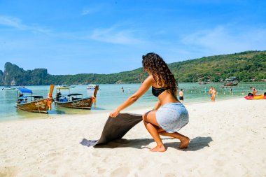 Muhteşem Lübnanlı genç kadın Tayland 'daki Koh Phi Adaları' ndaki tatilinde havlusunu kumsala yayıyor.