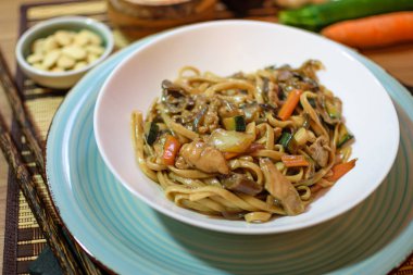 Sebzeli pirinç eriştesi ve beyaz kasede et. Ahşap arka. Kapatın. Üst görünüm